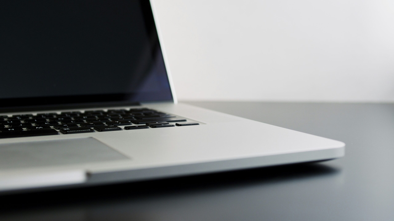 silver laptop computer on black table