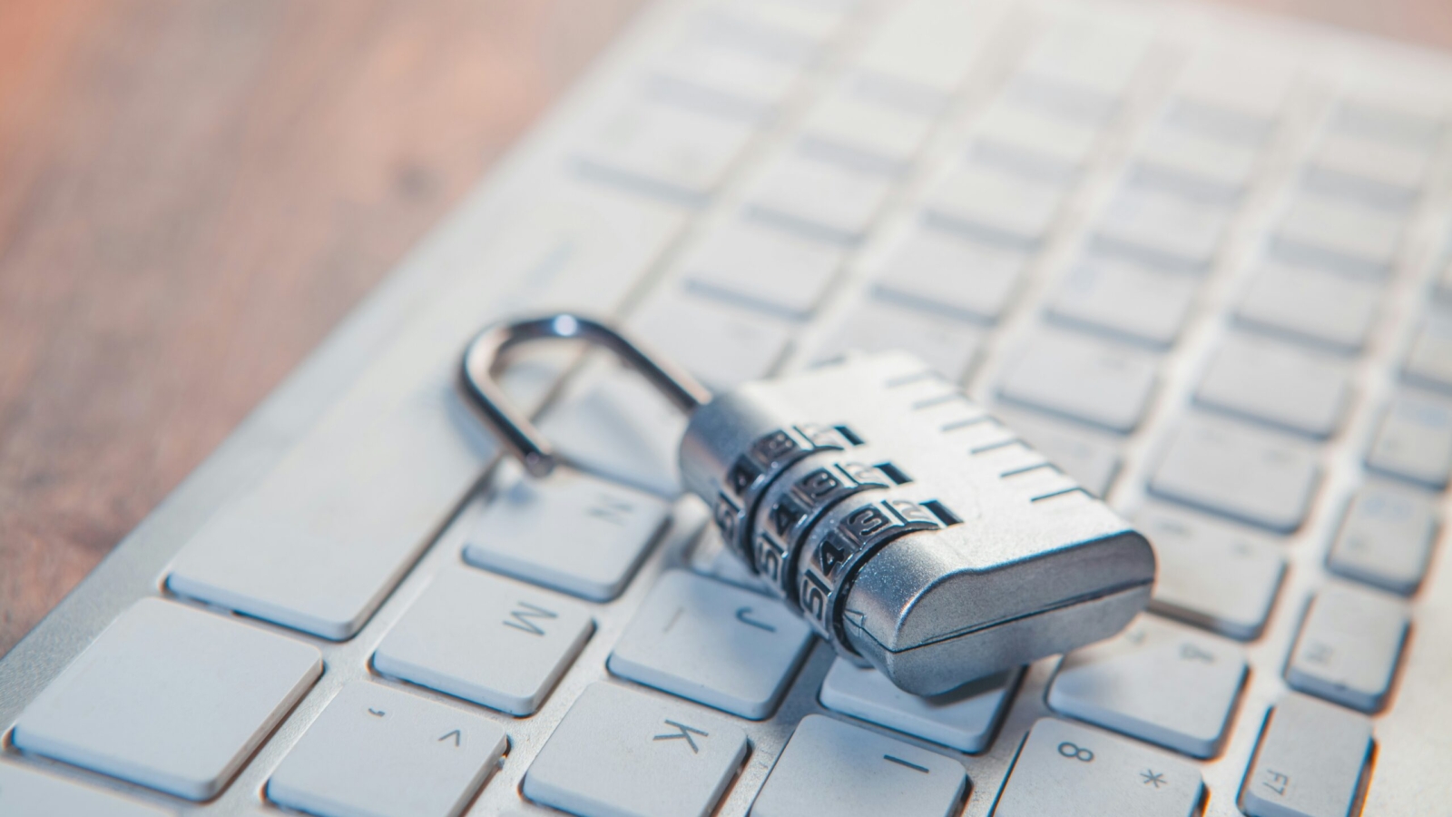 A combination lock rests on a computer keyboard.