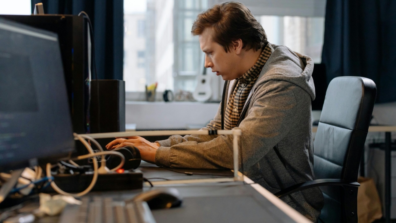 Free A concentrated professional working at a computer in a modern office setting. Stock Photo