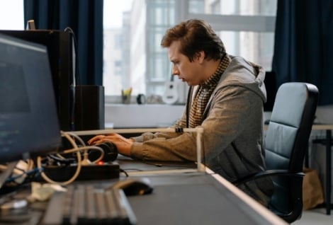 Free A concentrated professional working at a computer in a modern office setting. Stock Photo
